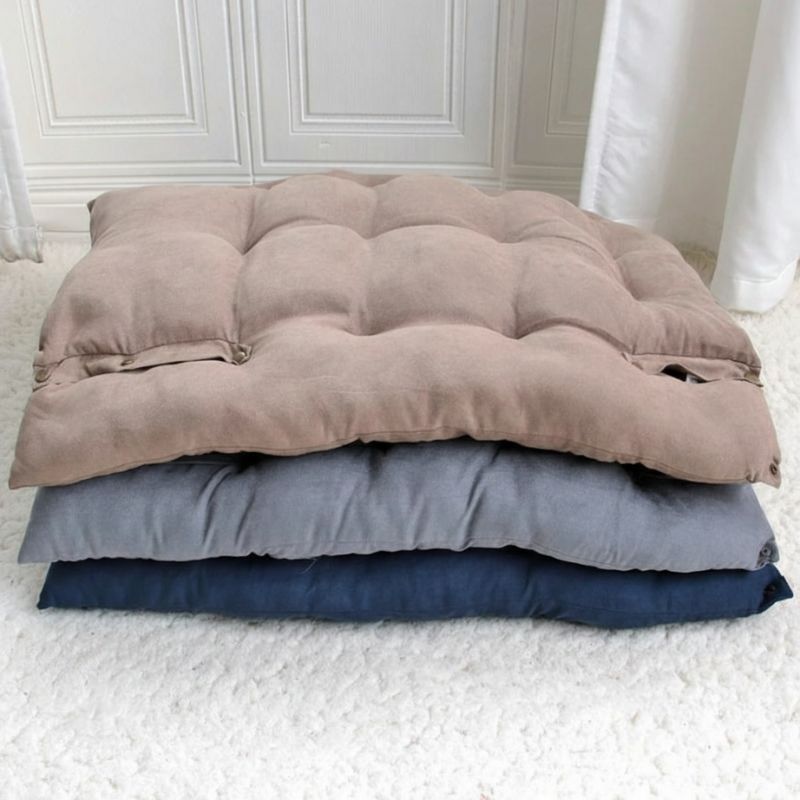 Stack of three folded comforters in brown, gray, and blue on a white surface.