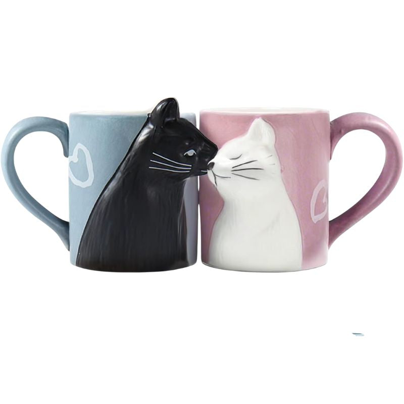 Two ceramic mugs shaped like black and white cats on a white background