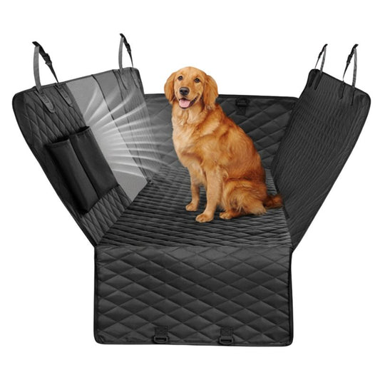 Dog sitting on a black car seat cover with a quilted design.